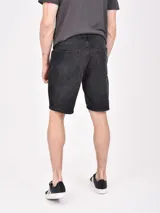 Bermuda de jean color negro con efecto lavado, de corte recto y largo hasta la rodilla.