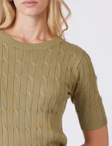 Buzo tejido marca Tahari, color verde, con cuello a la base, manga corta y diseño de ochos en el frente.