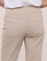 Pantalón de gabardina elastizada color beige, de corte recto, con bolsillos simulados en el frente y bolsillos aplicados en la parte trasera.