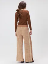 Pantalón de tejido jacquard con textura geométrica en tonos tostado y beige, de tiro medio, cintura elástica con cordón de ajuste y pierna ancha.
