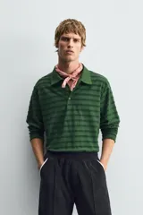 Polo de manga larga con cuello solapa y cierre frontal de botones. Presenta un tejido jacquard texturizado con rayas horizontales en tonos de verde.