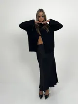 Falda midi negra de tela satinada, con cintura elástica y tajos laterales.