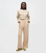 Pantalón wide leg de modal color beige, con tiro alto, pliegues delanteros y bolsillos laterales tipo cuchillo. Cuenta con trabillas en la cintura.