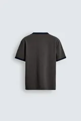 Camiseta de corte regular fit, color gris oscuro, con cuello redondo y bordes de mangas en color azul marino a contraste.