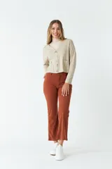 Cardigan tejido de punto con escote en V, cierre frontal con botones y bolsillos tipo cartera. Presenta un diseño de corte recto y mangas largas.