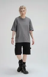 Remera de corte holgado y diseño minimalista, con cuello redondo y mangas cortas de hombros caídos. Confeccionada en algodón premium, presenta un largo a la altura de la cadera.