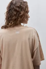 Remera negra de silueta amplia y calce relajado, con cuello redondo, mangas cortas con hombros caídos y estampa botánica en líneas blancas en el frente.