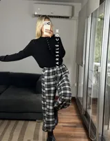 Pantalón estilo balloon de tela escocesa, con cintura elástica y cordón ajustable. Presenta un diseño holgado con puños elásticos en los tobillos.