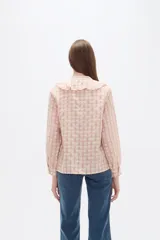 Blusa de viscosa con estampado de cuadros y pequeños puntos, diseño holgado, cuello a la base con volados frontales, cierre de botones y mangas largas con puños.