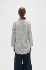Blusa de viscosa con estampado floral pequeño, cuello mao con escote en V y cierre frontal parcial de botones. Presenta mangas largas con puños y un bolsillo frontal en el pecho.