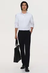 Camisa de corte entallado confeccionada en tejido elástico de mezcla de algodón, con cuello italiano, cierre frontal de botones y mangas largas con puños ajustables.