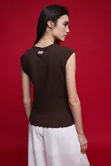 Remera sin mangas de silueta entallada y corte al cuerpo, confeccionada en algodón elastizado con textura acanalada y escote redondo.