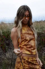 Top de cuero sin mangas con cuello halter y estampa marmolada en tonos tostados y marrones.