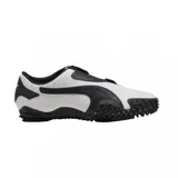 Championes Puma modelo Mostro Perforated, de diseño bajo con exterior de cuero perforado en color blanco y detalles en negro. Presenta una suela distintiva con relieve de tachones y cierre de velcro en el empeine.
