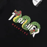 Remera negra Thrasher con estampado del logo de la marca con diseño de serpientes aztecas en blanco, verde y rojo.