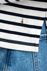 Remera de manga larga con cuello redondo, corte ajustado al cuerpo y patrón de rayas horizontales anchas en blanco y azul marino.