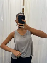 Musculosa negra con acabado satinado y sutil brillo, de corte holgado y diseño básico con breteles anchos.