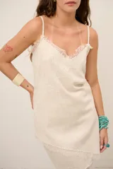 Top celeste con tirantes finos y detalles de encaje marrón en el escote y el dobladillo inferior.