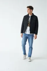 Campera negra de nylon capitoneada, con cuello medio y bolsillos tipo sobre con botón.