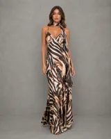 Vestido largo de satén con estampado animal print en tonos tierra, escote en V con tirantes finos y detalle de pañuelo integrado al cuello.