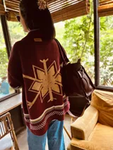 Cardigan tejido artesanalmente en lana color crudo, con diseño de copo de nieve en la espalda y bordados a mano.