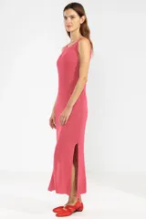 Vestido largo tejido en jersey fucsia, con escote redondo y abertura lateral.