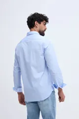 Camisa de manga larga fit semi slim color celeste, con cierre frontal de botones y cuello camisero clásico.