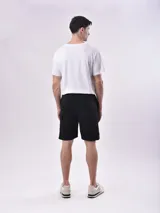 Bermuda cargo color negro con bolsillos laterales con solapa, cintura elástica con cordón ajustable y corte relajado.