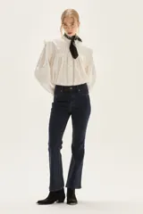 Jean de mezclilla azul marino, tiro medio, con silueta ligeramente acampanada desde la rodilla.