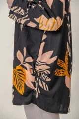 Blusa negra con estampado de hojas color naranja y beige, cuello redondo y mangas 3/4.