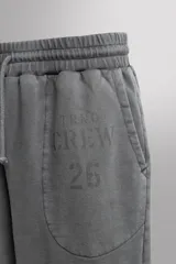 Short tipo jogger de algodón con interior afelpado, cintura elástica ajustable con cordón, bolsillos frontales y bolsillo trasero. Presenta un efecto lavado y estampado gráfico a contraste en el frente.