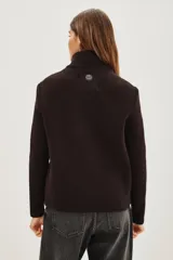 Campera híbrida de diseño moderno, con frente acolchado tipo puffer en acabado brillante y mangas tejidas en punto acanalado. Presenta cuello alto tejido y cierre frontal con botones a presión.
