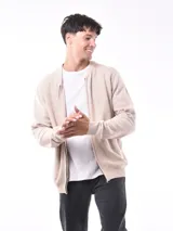 Campera tejida de punto con cierre frontal, cuello redondo y puños acanalados. Presenta una textura sutil en el tejido y un diseño versátil.