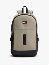 Mochila outdoor Tommy Jeans color beige con base negra, bolsillo principal con cierre, bolsillos laterales de red y asa superior. Cuenta con detalles distintivos de la marca y logo bordado en el frente.