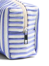 Neceser rectangular con cierre de cremallera, confeccionado en tela con estampado de rayas verticales en azul y blanco.