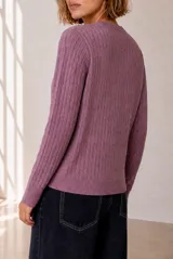 Cardigan de punto con diseño de ochos, color rojo, cuello redondo y cierre frontal con botones. Cuenta con manga larga y detalle bordado en el pecho.