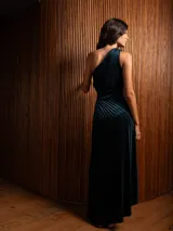 Vestido largo de terciopelo con diseño de un solo hombro y textura plisada. Presenta un corte ajustado en la cintura y una caída fluida hasta el suelo.