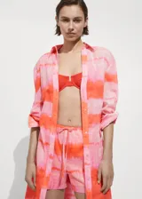 Short de algodón con diseño estampado en tonos rosados y naranjas, corte recto, cintura elástica con lazo ajustable y bolsillos laterales.