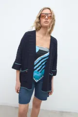 Kimono abierto de tejido de punto azul marino, con mangas tres cuartos y bolsillos frontales con detalles en hilo turquesa.