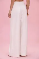 Pantalón sastrero de lino color blanco off white, de corte recto y amplio, con pinzas en la parte delantera.