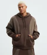 Saco cerrado con capucha, color marrón con recortes contrastantes en un tono más claro de marrón. Confeccionado en algodón y poliéster, tiene cordón para ajustar la capucha, bolsillos tipo canguro y manga larga.