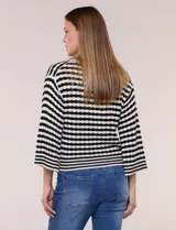 Blusa tejida de punto a rayas horizontales blancas y negras, con cuello polo y escote en V profundo. Presenta hombros caídos, mangas 3/4 estilo campana y corte holgado.