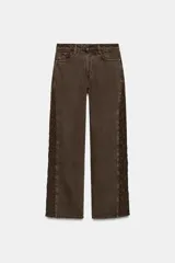 Jeans de tiro medio y corte recto, color marrón chocolate. Presenta un diseño de cinco bolsillos y detalles laterales con tejido de crochet a tono a lo largo de las piernas.