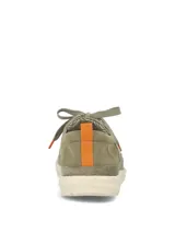 Zapatos slip-on color verde militar, confeccionados en lona y gamuza, con cordones elásticos y suela blanca.
