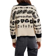 Cárdigan de punto con cuello tipo camisa y cierre frontal de botones. Presenta un diseño estampado floral en contraste sobre fondo claro, con puños y ruedo acanalados.