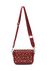 Bandolera pequeña de color rojo con solapa frontal decorada con tachas metálicas plateadas. Incluye una correa larga ajustable de tela al tono y herrajes metálicos.
