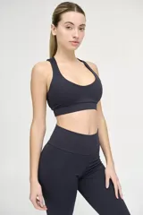 Top deportivo negro con escote redondeado, espalda cruzada y cintura con doble tela.