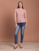 Cardigan blanco de tejido fino con abertura central y botones.