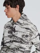 Buzo con capucha Calvin Klein confeccionado en mezcla de algodón y poliéster con estampado abstracto en tonos grises. Presenta cuello con capucha, puños y dobladillo de punto canalé, bolsillo de canguro y logo de Calvin Klein en la parte delantera.