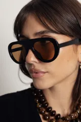 Lentes de sol con armazón de policarbonato color marrón traslúcido y diseño envolvente de una sola pieza.